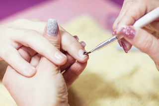 Applying nail dehydrator to a natural nail during a professional manicure service.